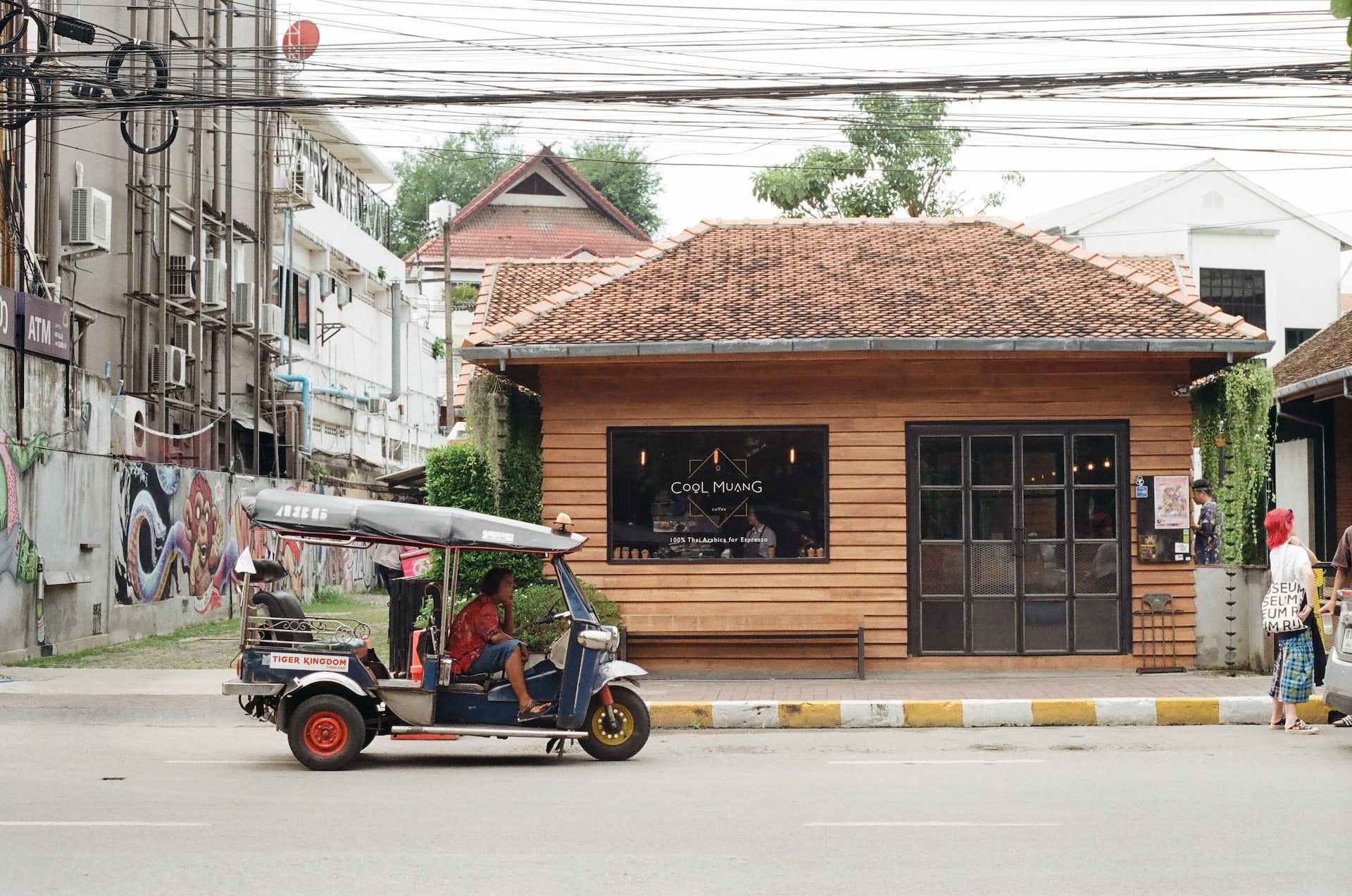 A coffee shop and a small vehicle in a Thai city.