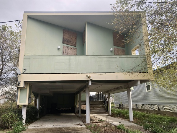 A boarded-up house on stilts