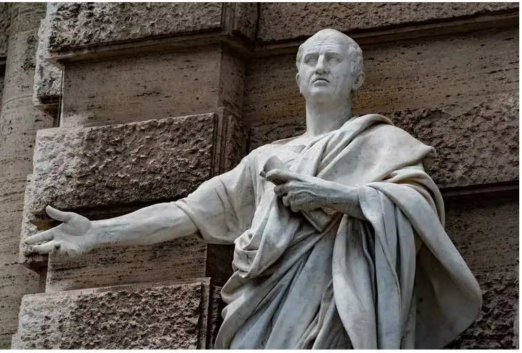 A marble statue of a Roman emperor with an arm outstretched. A marble statue of a Roman emperor with an arm outstretched.
